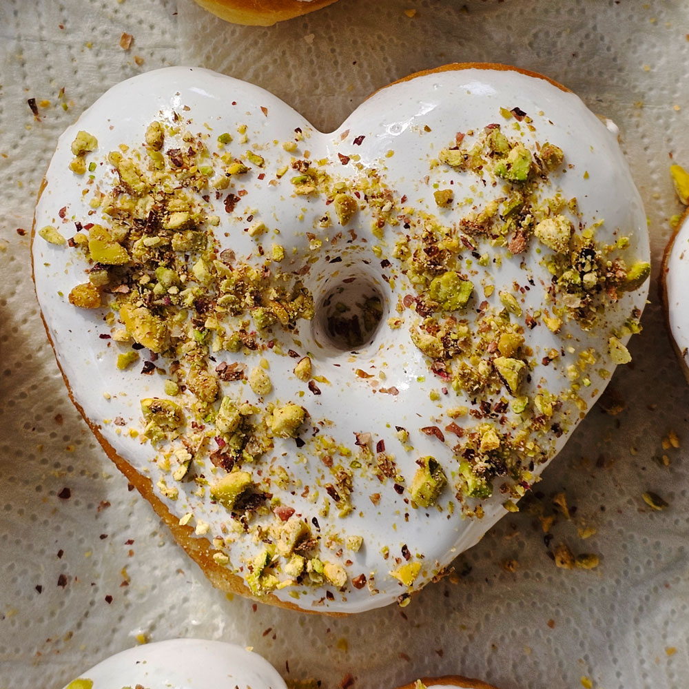 Lemon glaze pistachio heart donuts side by side