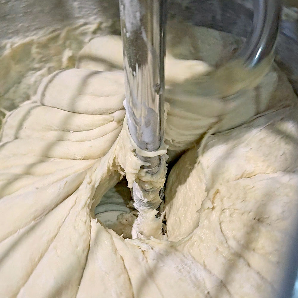 Dough mixing on a hook in the kitchen bowl
