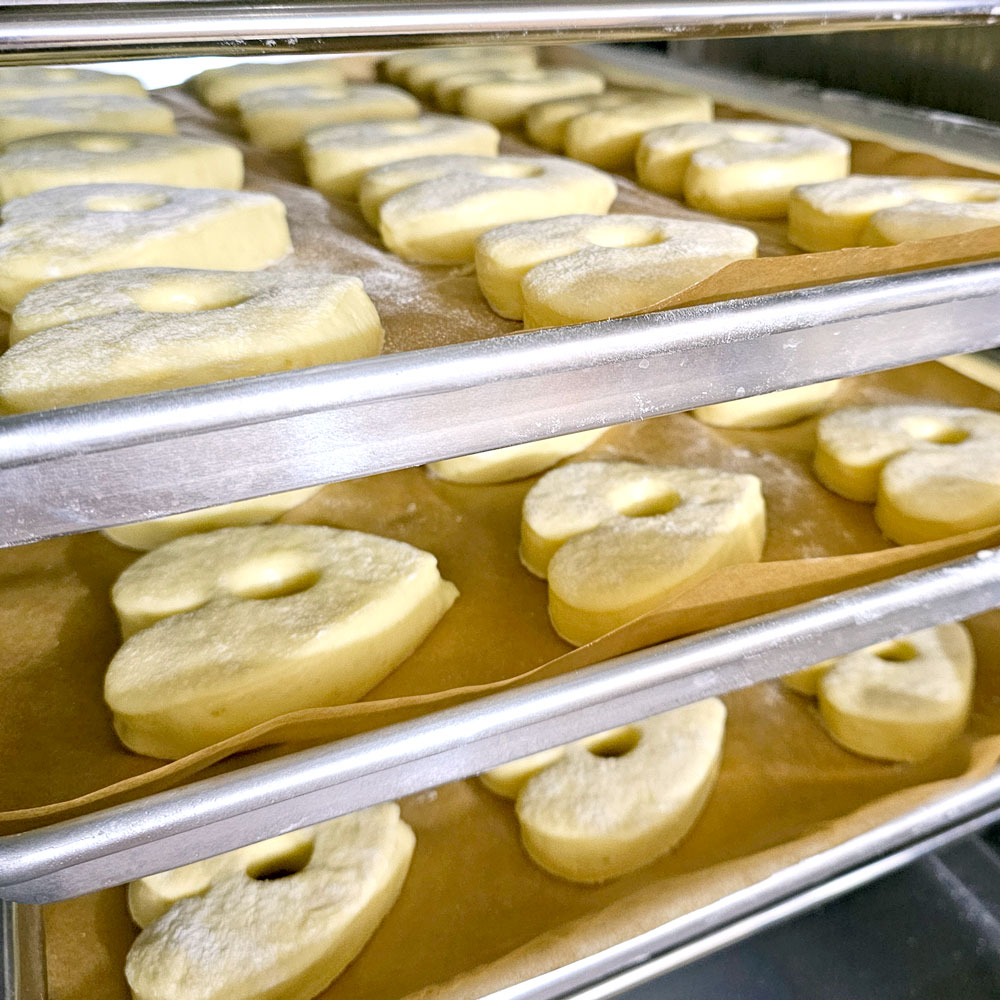 Pale heart dough proving on stacked bakery trays