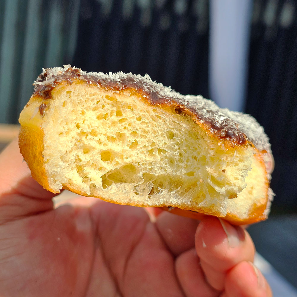Chocolate coconut heart donut torn open