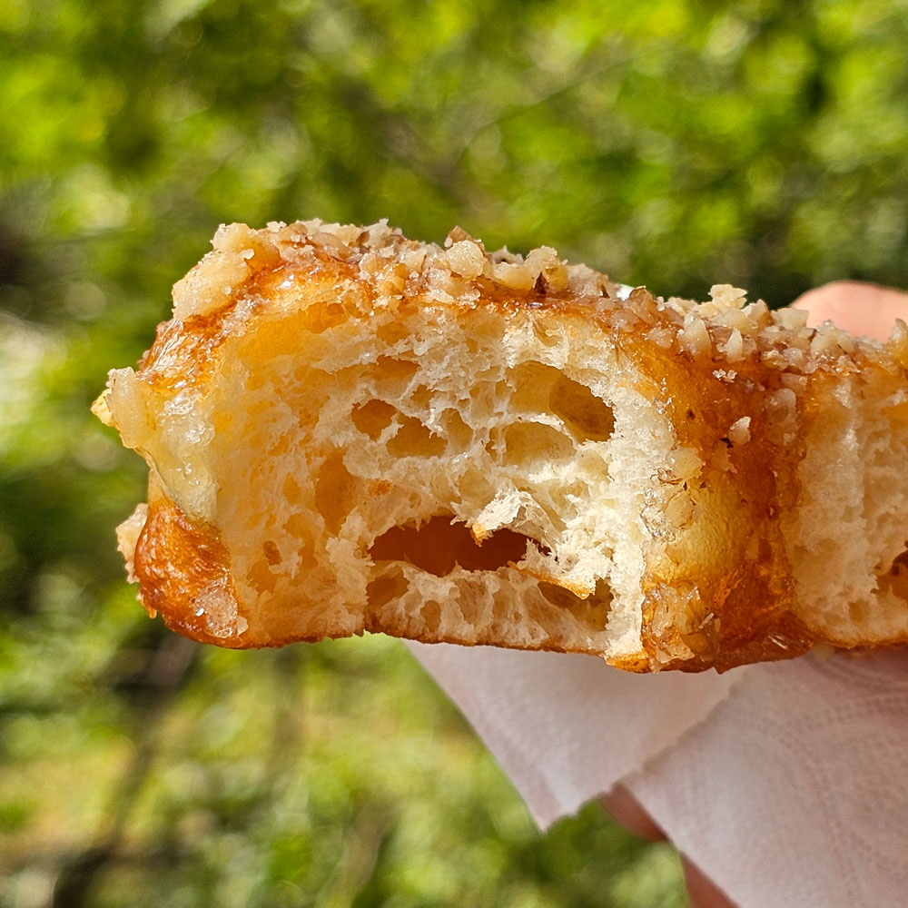 Lemon glaze pistachio heart donut torn open
